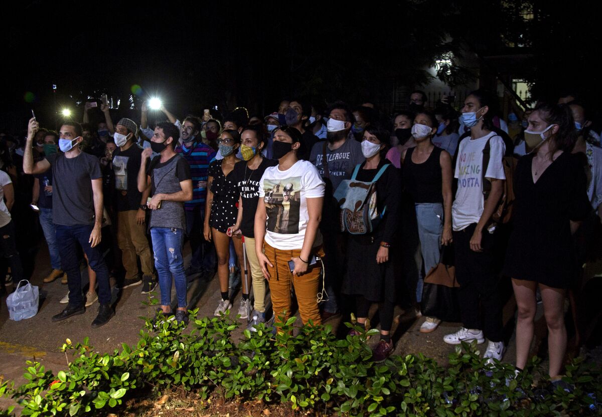 Masked protesters stand together in Havana