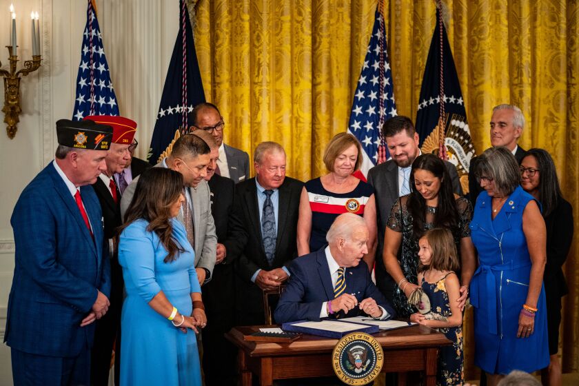 WASHINGTON, DC - AUGUST 10: President Joe Biden delivers remarks and signs S. 3373, the Sergeant First Class Heath Robinson Honoring our Promises to Address Comprehensive Toxics (PACT) Act of 2022 into law during an event in the East Room of the White House on Wednesday, Aug. 10, 2022 in Washington, DC. The bill will expand access to Veterans Affairs (VA) health care and benefits for toxic exposed veterans and their survivors, increase research related to toxic exposures, and provide the VA with more resources to serve veterans, their families, caregivers and survivors. (Kent Nishimura / Los Angeles Times)