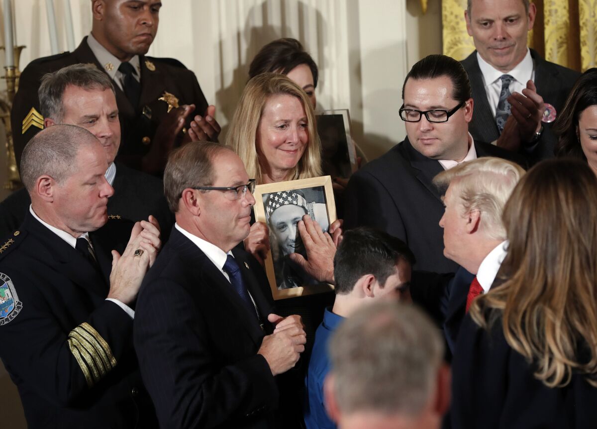 President Trump touches a photo of Adam Moser,  who died from an apparent fentanyl overdose. 