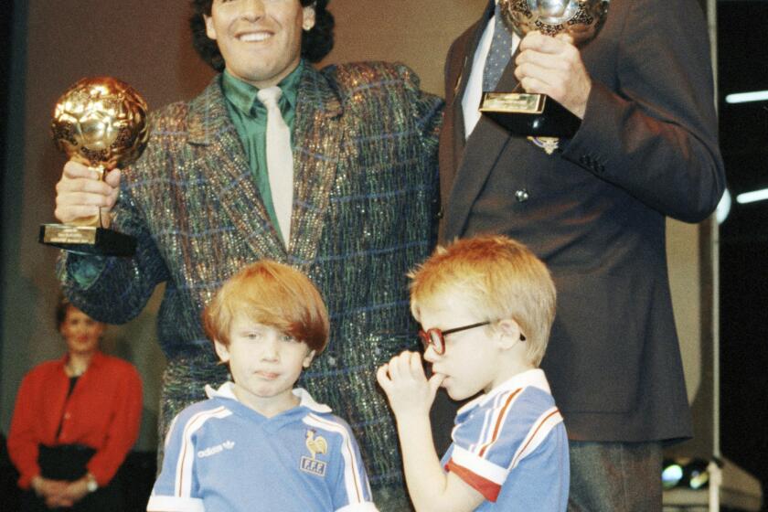 ARCHIVO - Foto del 13 de noviembre de 1986, la estrella argentina Diego Maradona posa con el portero alemán Harald Schumacher con sus premios tras la Copa Mundial 1986. El martes 7 de mayo del 2024, reaparece el Balón de Oro perdido que ganó Maradona en 1986 y será subastado en París. (AP Foto/Michael Lipchitz, Archivo)