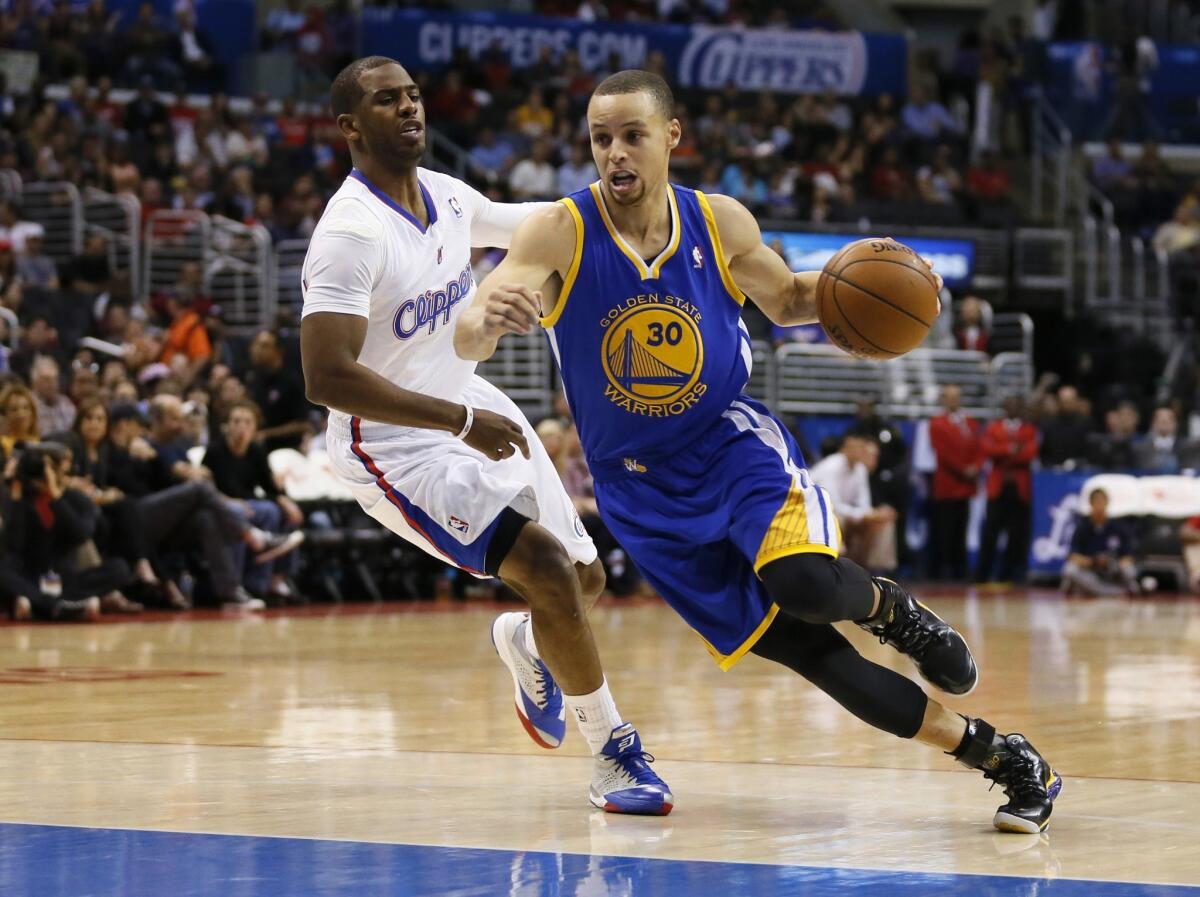 Golden State Warriors point guard Stephen Curry, right, drives around Clippers point guard Chris Paul at Staples Center on March 12.