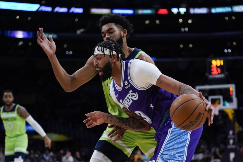 Lakers forward Anthony Davis drives past Timberwolves center Karl-Anthony Towns.