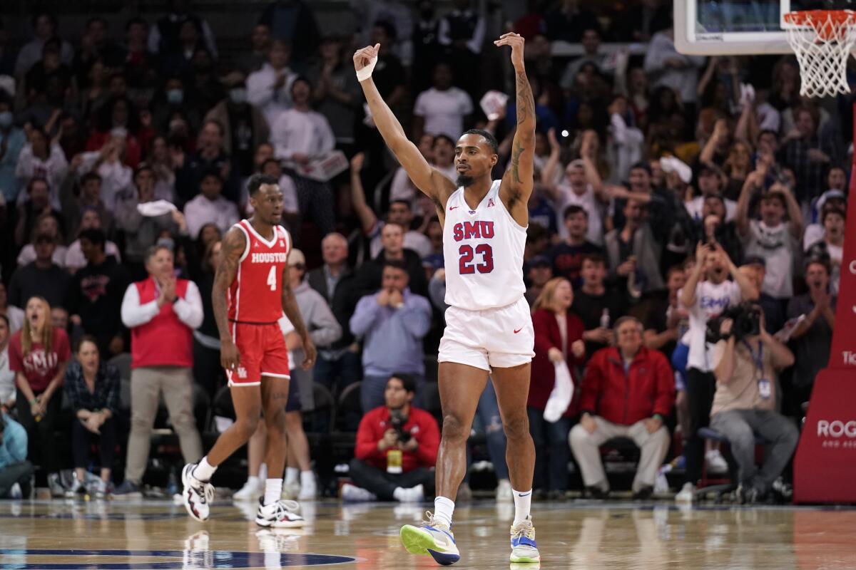 SMU's Michael Weathers (23) calls for more cheers from fans late in the second half as Houston's Taze Moore (4) follows behind during an NCAA college basketball game in Dallas, Wednesday, Feb. 9, 2022. (AP Photo/Tony Gutierrez)