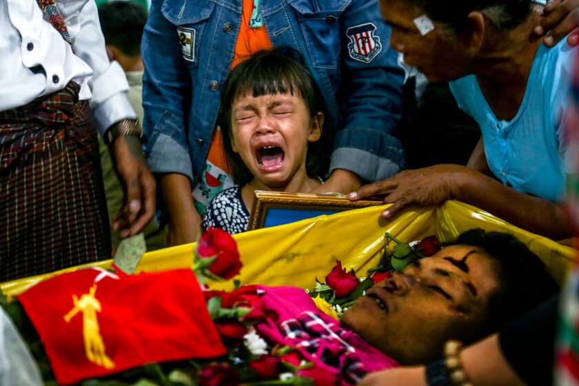 دختر بچه ای بر روی تابوت باز پدرش گریه می کند 