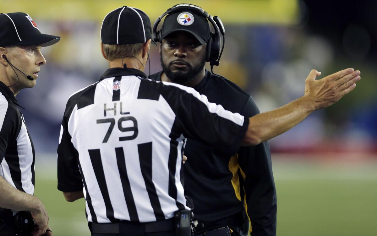 Steelers Coach Mike Tomlin listens to head linesman Kent Payne, center, alongside side judge Scott Novak in the first half against the Patriots.
