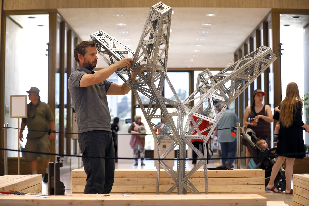 Roman de Salvo, the artist-in-residence at the Timken Museum of Art, works on his “Electric Picnic” installation at the Balboa Park museum.