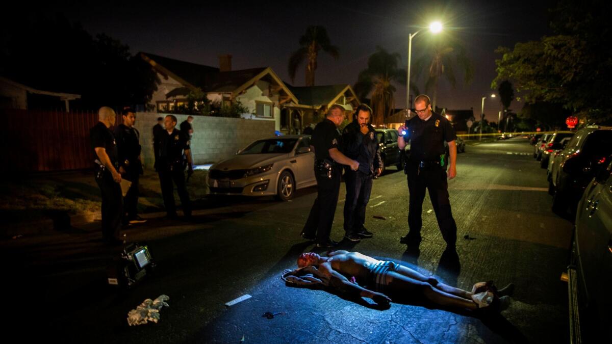 LAPD officers and detectives respond to a man shot dead in a car in South LA.