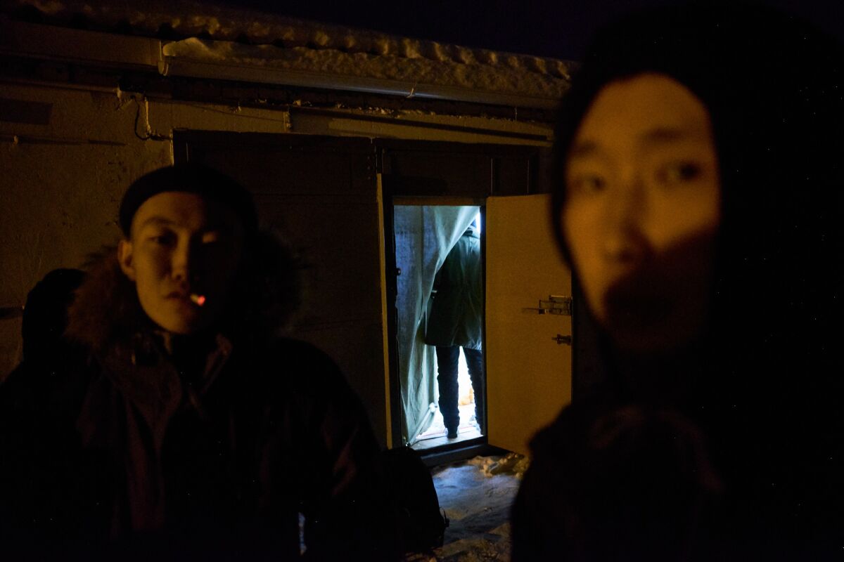 Yakutian punk rock band members smoke outside a friend's garage apartment on the outskirts of Yakutsk.