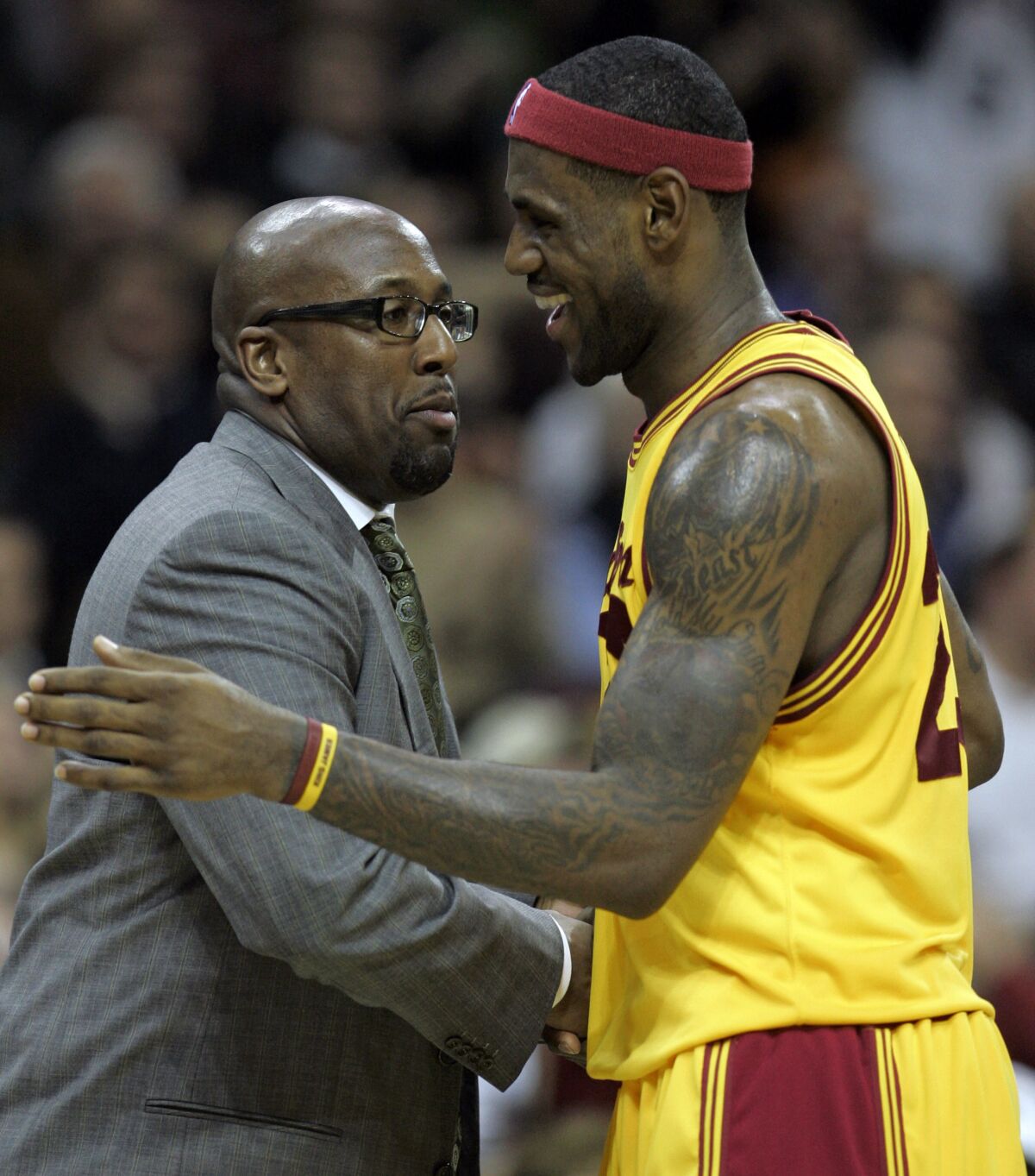LeBron James smiles as he talks with Cavaliers coach Mike Brown during a game on Dec. 3, 2008, in Cleveland.