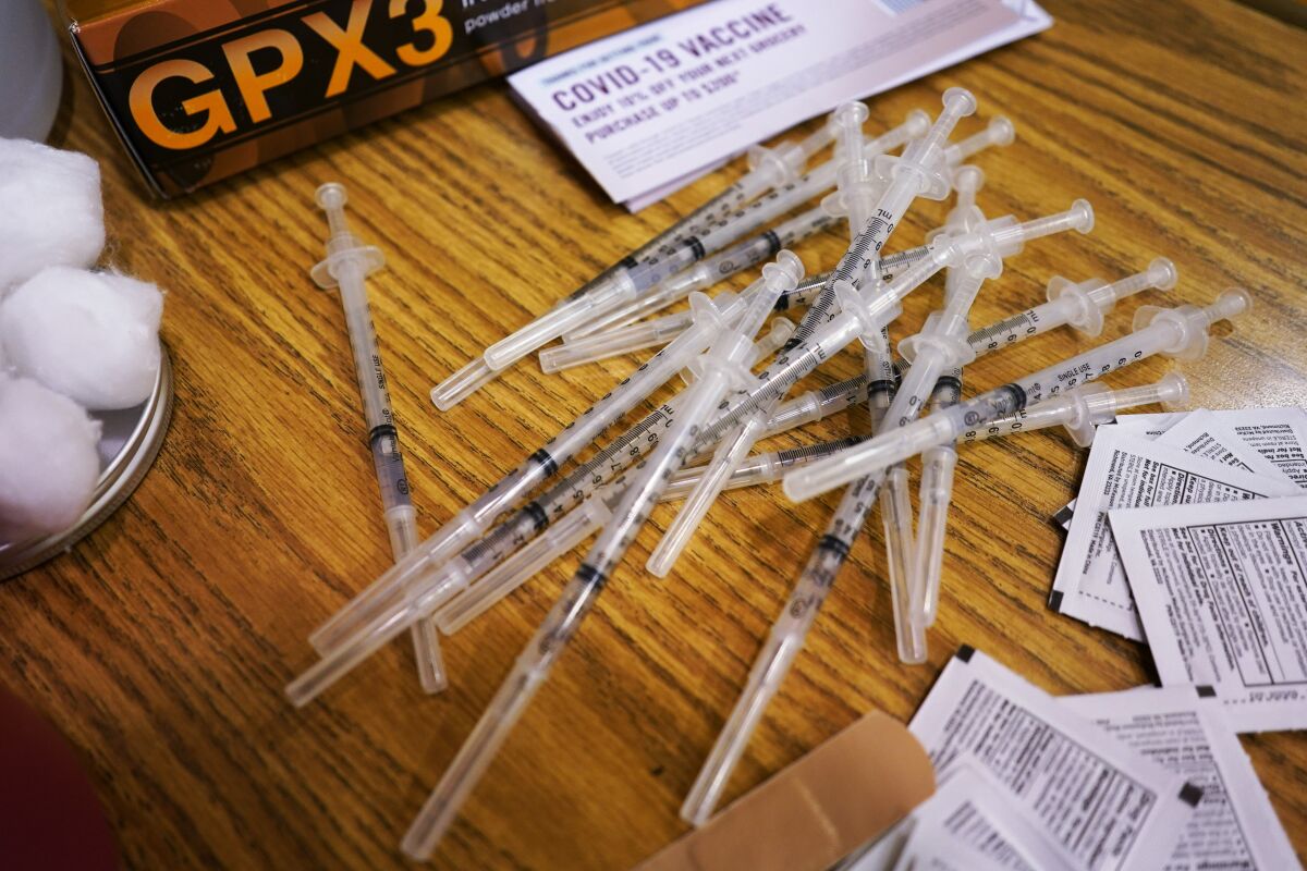 FILE - Prepared Pfizer COVID-19 vaccine syringes wait for patients at a middle school in Wheeling, Ill., Friday, June 11, 2021. As demand for COVID-19 vaccines collapses in many areas of the U.S., states are scrambling to use stockpiles of doses before they expire and have to be added to the millions that have already gone to waste. (AP Photo/Nam Y. Huh, File)