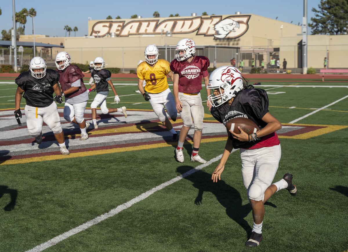 Isis Salazar takes a hand off during Ocean View's football practice on Wednesday.