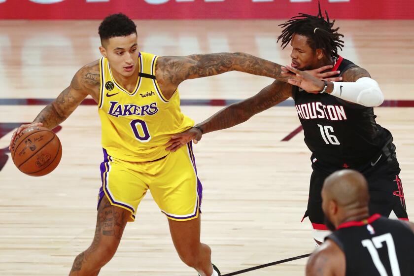 Los Angeles Lakers forward Kyle Kuzma (0) dribbles while defended by Houston Rockets forward Ben McLemore.