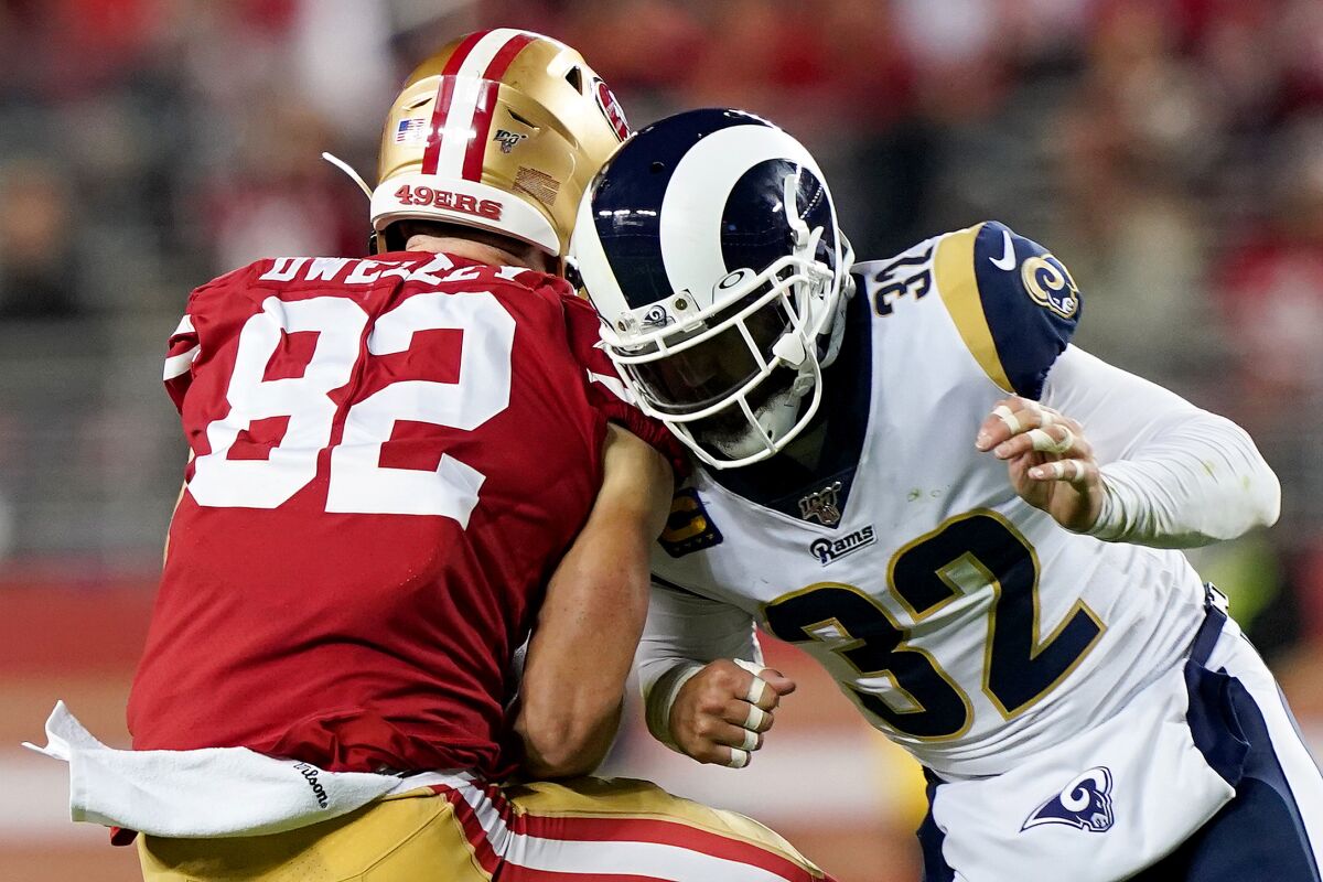 Rams safety Eric Weddle puts a hit on San Francisco 49ers tight end Ross Dwelley after he makes a first-down catch Saturday.