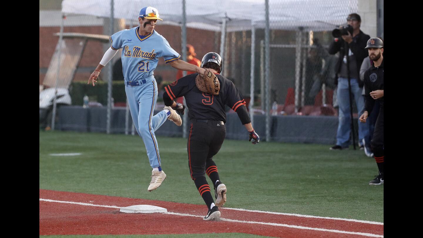 La Mirada High first baseman Emilio Morales (21) makes the tag on Huntington Beach's Josh Hahn during the second inning of a Boras Classic South tournament opener at Mater Dei High on Tuesday.