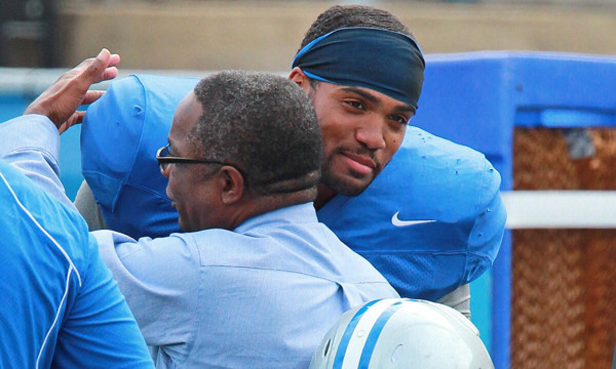 Middle Tennessee State defensive end Steven Rhodes hugs university president Dr. Sidney McPhee during a team practice session Monday.