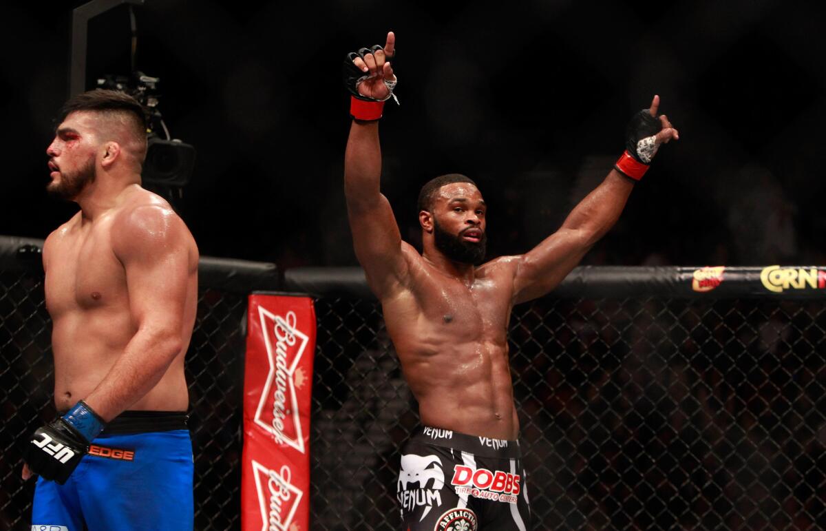 Tyron Woodley raises his arms after the third round of his welterweight bout against Kelvin Gastelum at UFC 183 on Saturday night in Las Vegas. Woodley won by split decision.