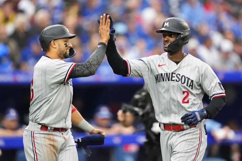 Minnesota Twins' Michael A. Taylor (2) celebrates his two-run home run against the Toronto Blue Jays with Royce Lewis (23) during the fifth inning of a baseball game Friday, June 9, 2023, in Toronto. (Mark Blinch/The Canadian Press via AP)