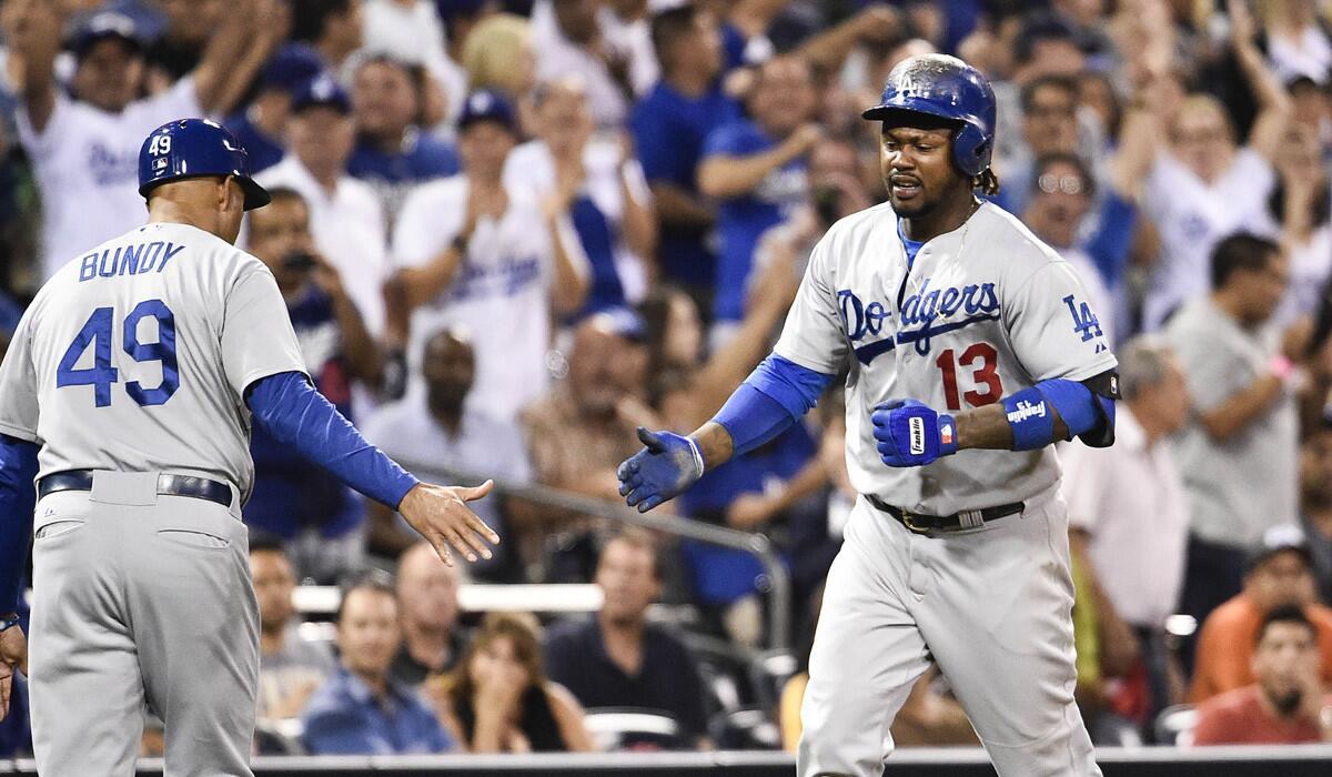 Dodgers shortstop Hanley Ramirez is congratulated by third base coach Lorenzo Bundy after hitting a solo home run against the Padres in the eighth inning Friday night in San Diego.