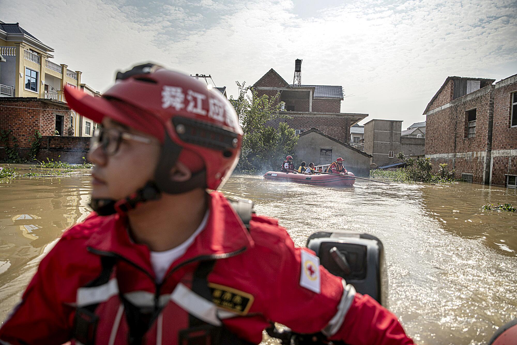 Rescue volunteers bring villagers back to retrieve items from their flooded home.