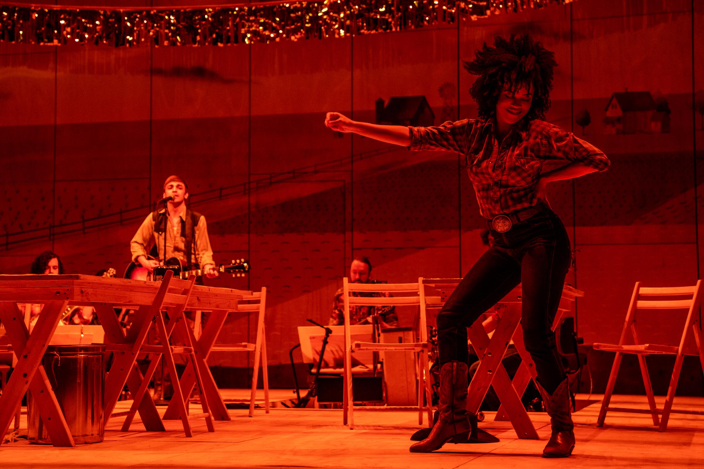 A woman dances on a stage that glows red.