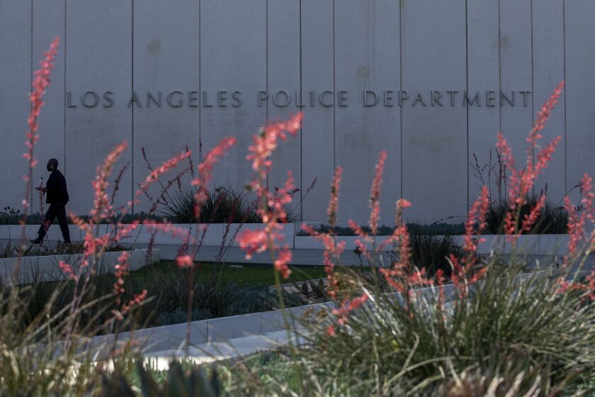 LOS ANGELES, CA - JUNE 03, 2021: A person makes her way into LAPD Headquarters in downtown Los Angeles. (Mel Melcon / Los Angeles Times)