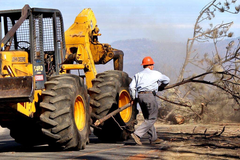 Sam Cover, 40, removes a snag from Cherry Oil Road near the community of Groveland, about 120 miles west of Yosemite National Park. Cover was a member of a crew doing emergency contract work for San Francisco Water and Power in a portion of the Stanislaus National Forest damaged by the Rim fire.