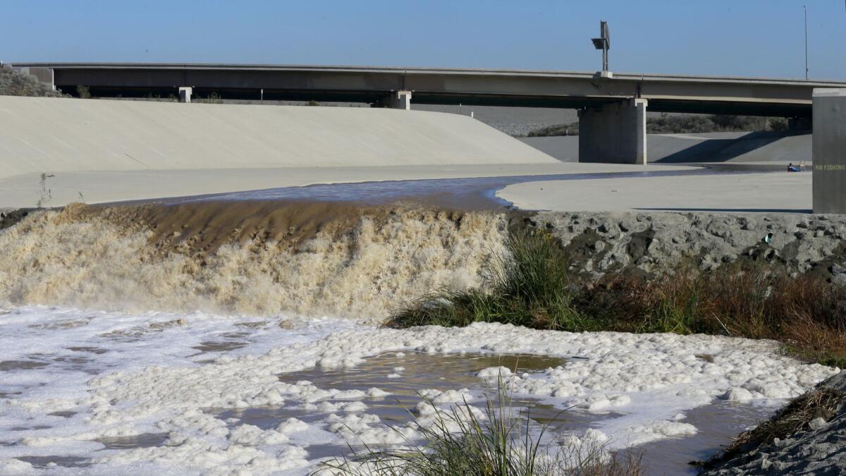 Stormwater flows down the Santa Ana River channel from Prado Dam while hydrologic technicians with the USGS California Water Science Center conduct high-flow velocity and volume measurements.