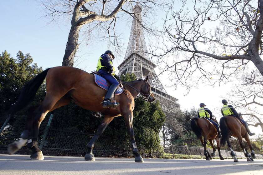 Mounted police officers patrol in front of the Eiffel Tower in Paris on Nov. 15.