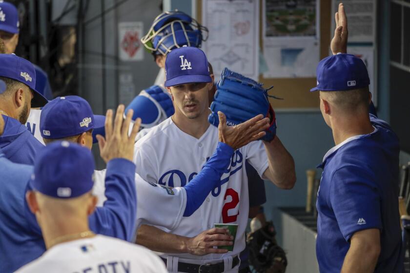LOS ANGELES, CA, THURSDAY, OCTOBER 3, 2019 - Los Angeles Dodgers starting pitcher Walker Buehler (21) is greeted in the dugout after pitching the third inning against the Nationals in game one of the National League Division Series at Dodger Stadium. (Robert Gauthier/Los Angeles Times)