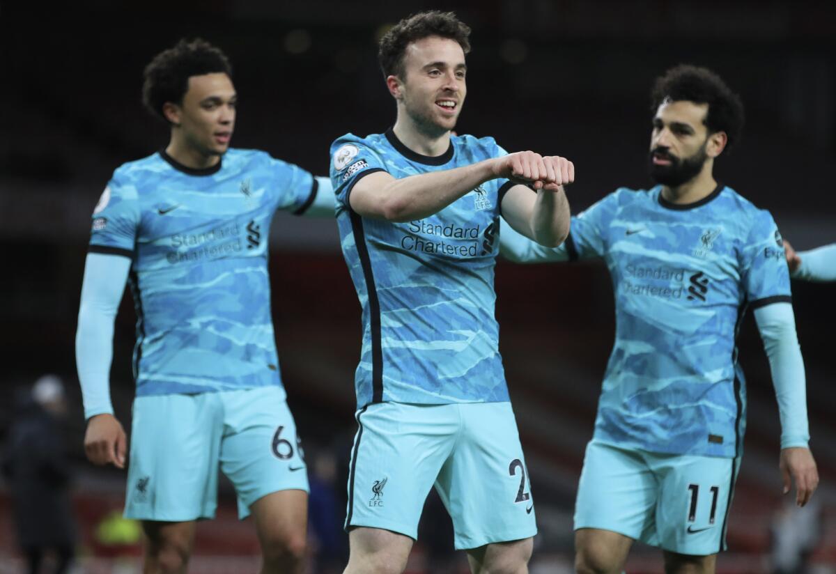 Liverpool's Diogo Jota, center, celebrates with teammates after scoring his sides first goal during the English Premier League soccer match between Arsenal and Liverpool at the Emirates Stadium in London, England, Saturday, April 3, 2021. (Adam Davy/Pool via AP)