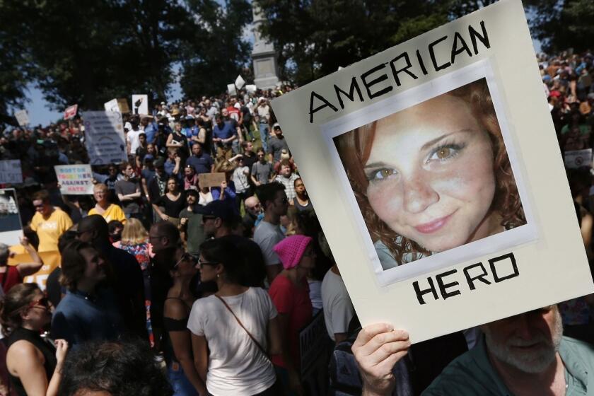 FILE - In this Aug. 19, 2017, file photo, a counter-protester holds a photo of Heather Heyer on Boston Common at a "Free Speech" rally organized by conservative activists, in Boston. Jury selection is set to begin in the trial of James Alex Fields Jr., accused of killing Heyer during a white nationalist rally in Charlottesville in 2017. His trial is scheduled to begin Monday, Nov. 26, 2018, in Charlottesville Circuit Court. (AP Photo/Michael Dwyer, File)