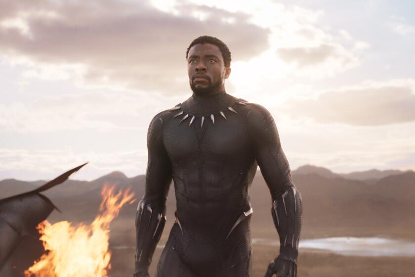 A man walking in a black superhero suit