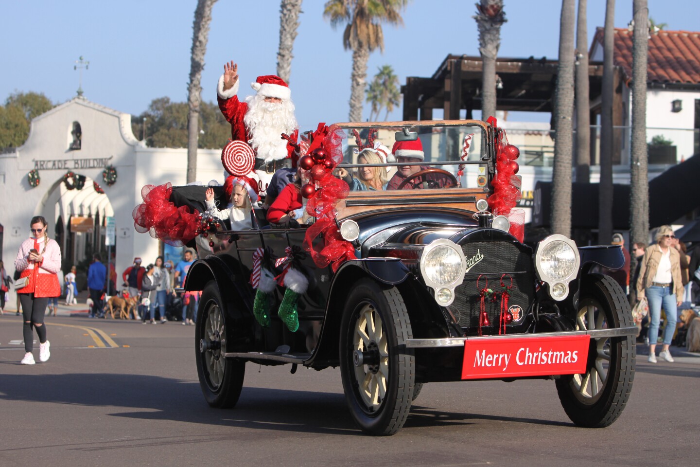 Rolling by on the traditional Old Black Goose car, Santa Claus waves during the La Jolla Christmas Parade on Dec. 5.