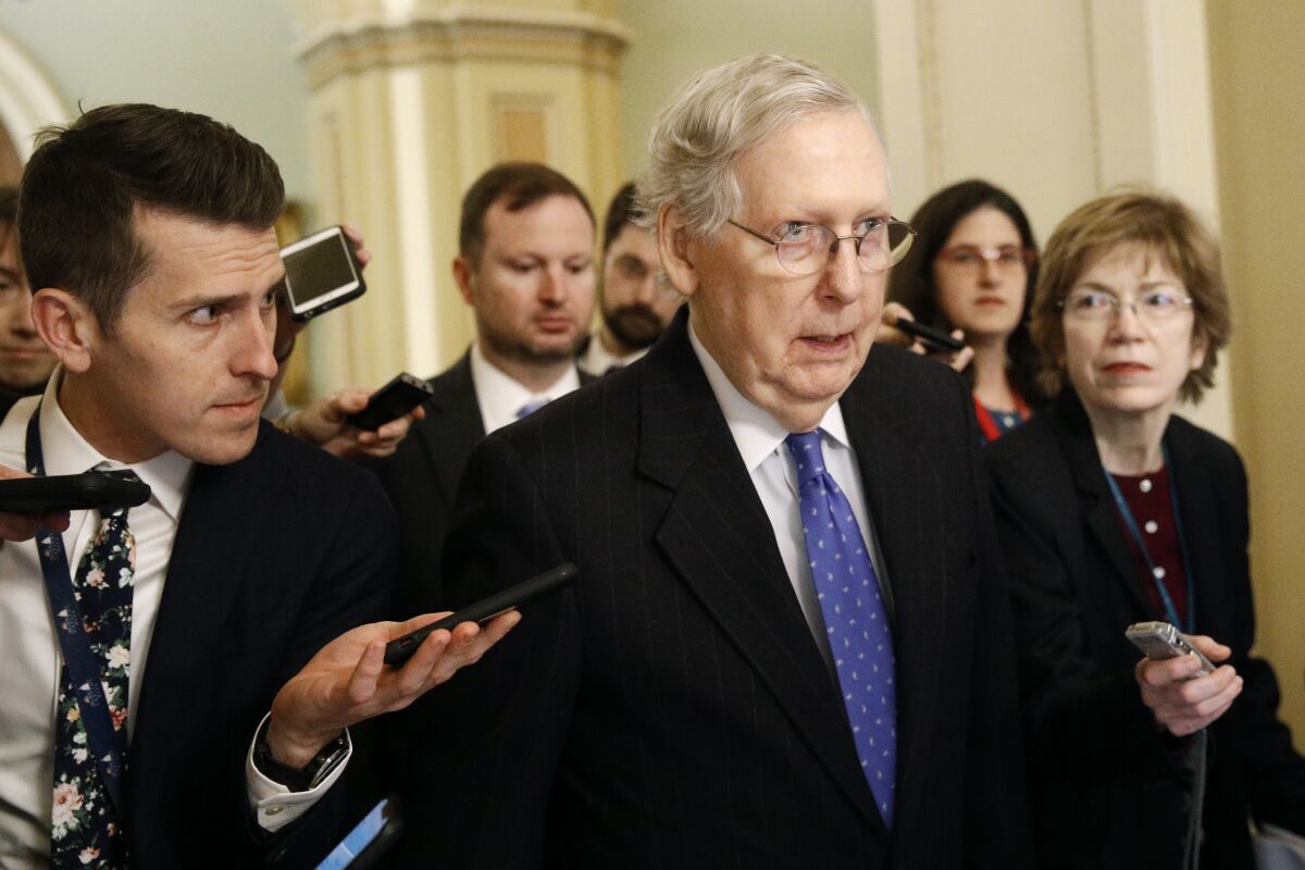 Senate Majority Leader Mitch McConnell speaks with reporters after walking off the Senate floor on Dec. 19.
