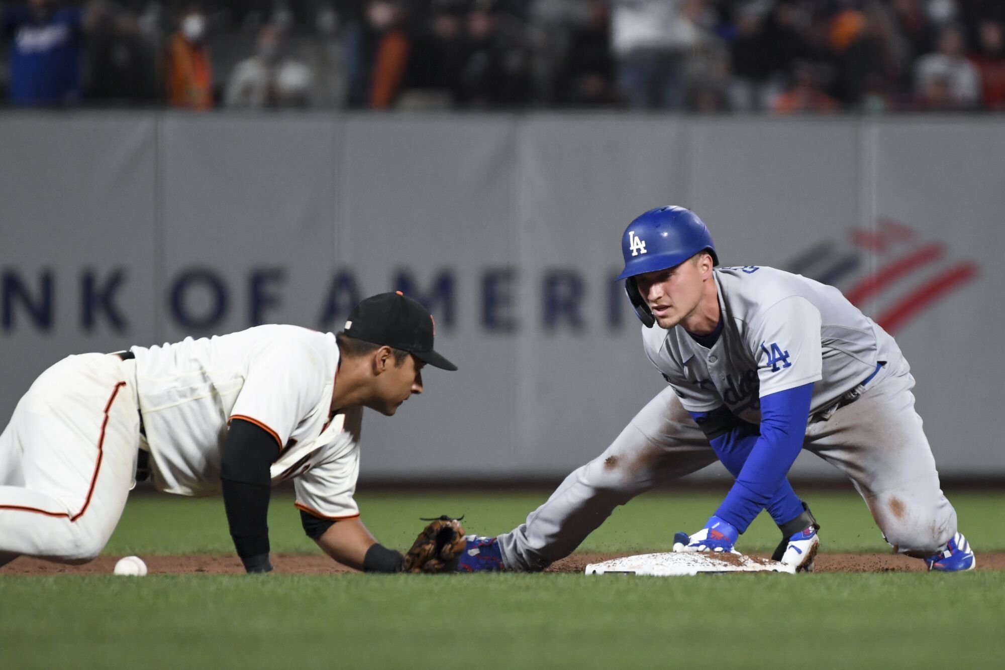 Dodgers' Corey Seager reaches second on a double in front of Giants second baseman Donovan Solano