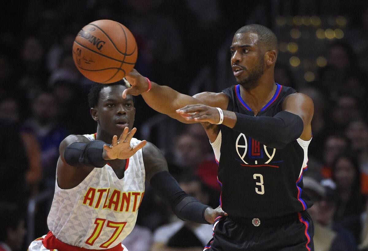 Clippers guard Chris Paul passes as Hawks guard Dennis Schroeder defends Saturday at Staples Center.