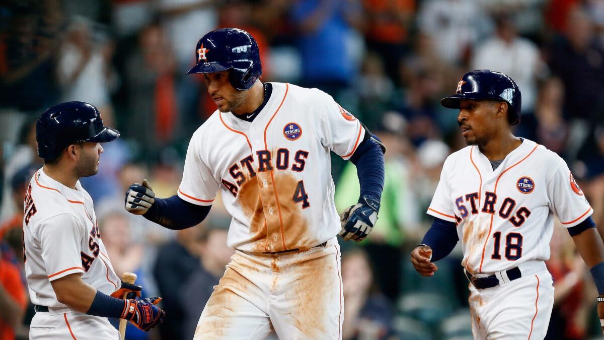 George Springer, center, is congratulated by Houston Astros teammates Jose Altuve, left, and Tony Kemp after hitting a home run in the second inning against the New York Mets in the first game of Saturday's doubleheader.