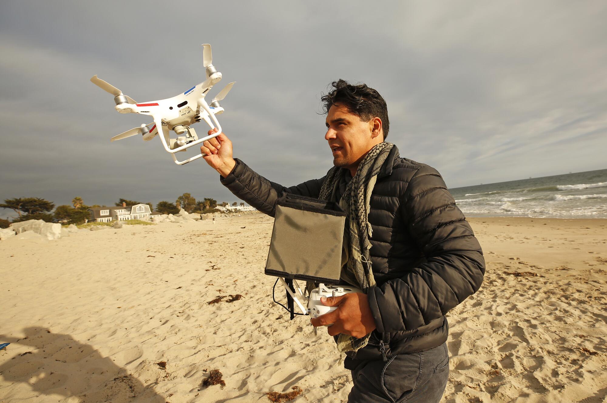 Drone photographer Carlos Gauna grabs his drone to avoid a sand landing