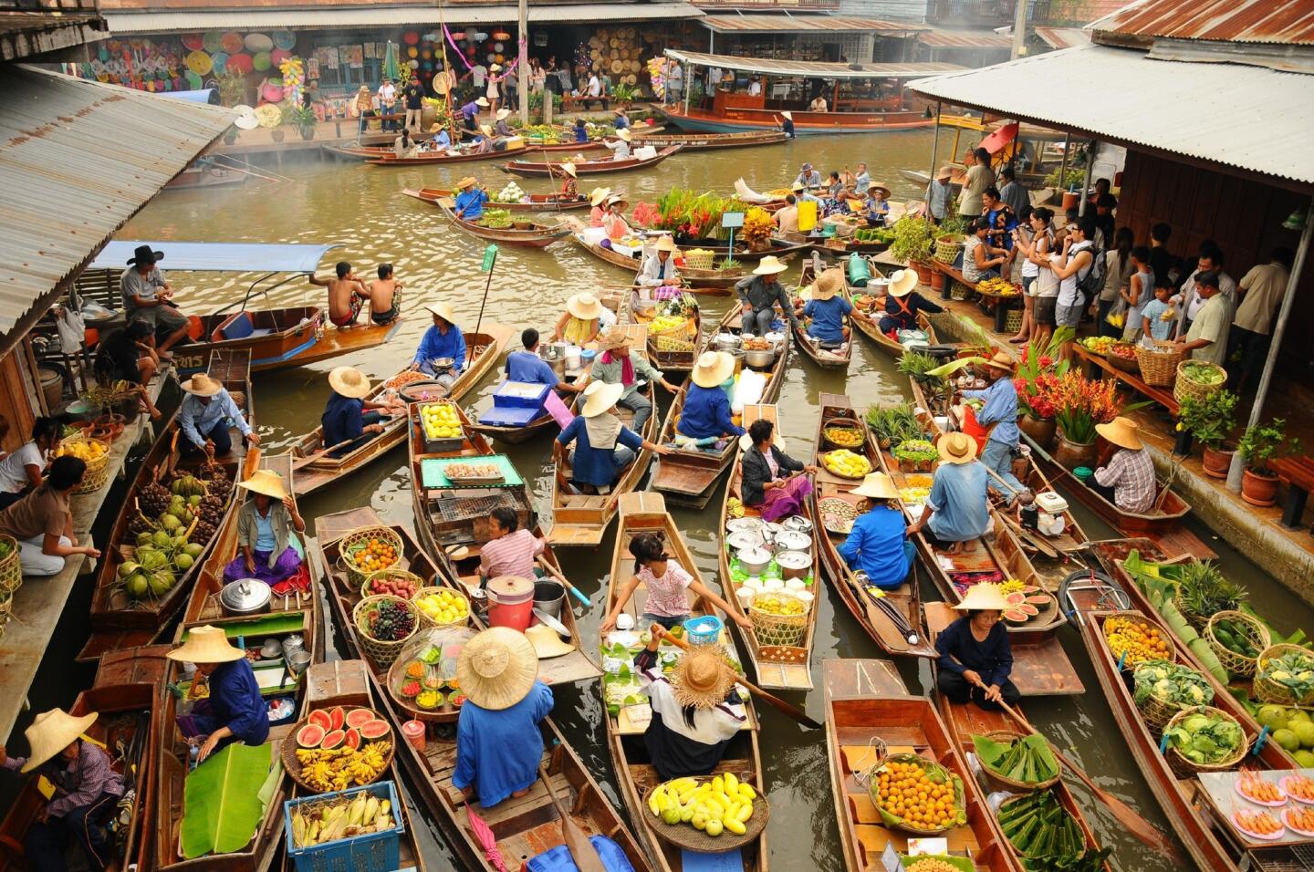 Wooden boats ferry people at the Amphawa Floating Market in Bangkok. This is a traditional and still popular method of buying and selling in the Amphawa canals. Bangkok's nickname is "Venice of the East." Head to Ayuthaya Historical Park (a UNESCO World Heritage site, 80 kilometers north of Bangkok) to see historic temples that are scattered throughout the former capital and along encircling rivers.