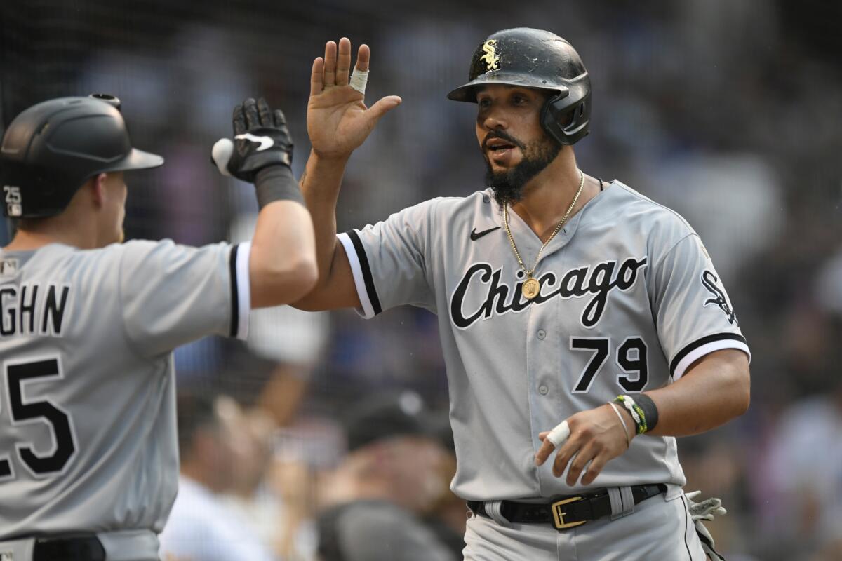 Chicago White Sox's Jose Abreu (79) celebrates with teammate Andrew Vaughn (25) after scoring on a Eloy Jimenez double during the second inning of a baseball game against the Chicago Cubs, Sunday, Aug 8, 2021, at Wrigley Field in Chicago. (AP Photo/Paul Beaty)