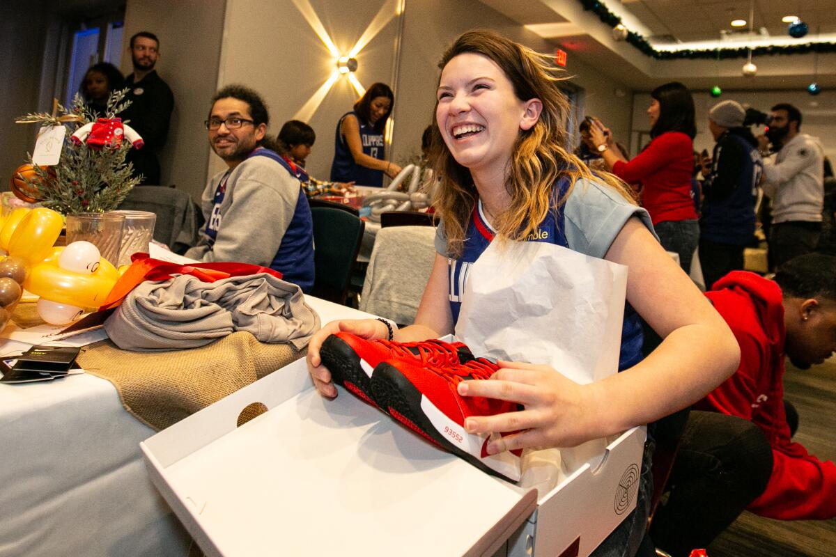 Rebecca Study, 13, opens a gift of new sneakers from LA Clippers star Paul George.