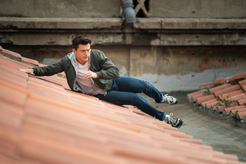 Tom Holland sliding down a rooftop