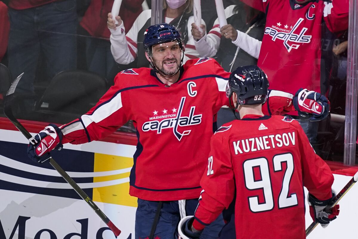 Washington Capitals left wing Alex Ovechkin (8) celebrates his first goal of the third period with center Evgeny Kuznetsov in an NHL hockey game, Wednesday, Oct. 13, 2021, in Washington. The Capitals won 5-1. (AP Photo/Alex Brandon)