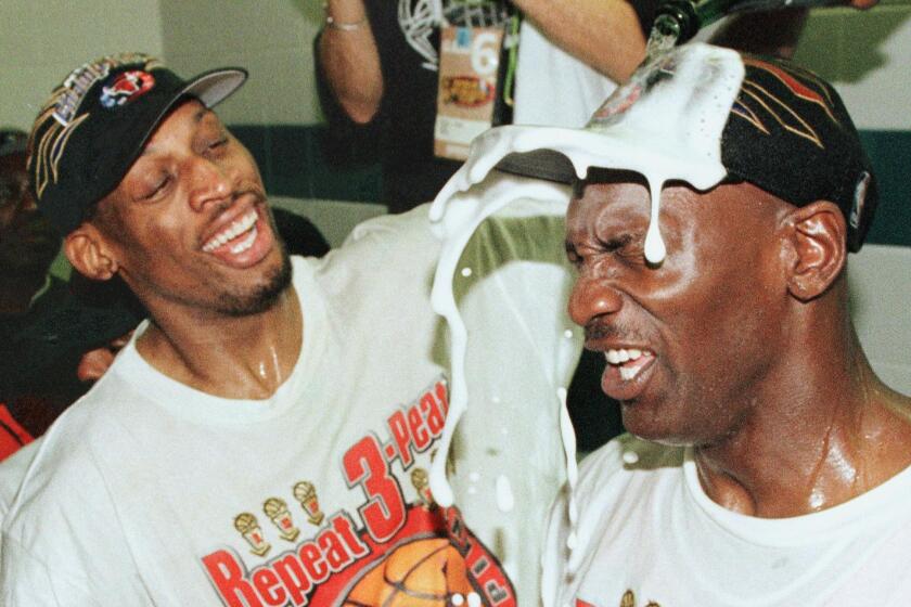 SALT LAKE CITY, UNITED STATES: Dennis Rodman (L) of the Chicago Bulls pours champagne on the head of teammate Michael Jordan (R) 14 June after winning game six of the NBA Finals with the Utah Jazz at the Delta Center in Salt Lake City, UT. The Bulls won the game 87-86 to win their sixth NBA championship. AFP PHOTO/Mike NELSON (Photo credit should read MIKE NELSON/AFP via Getty Images)
