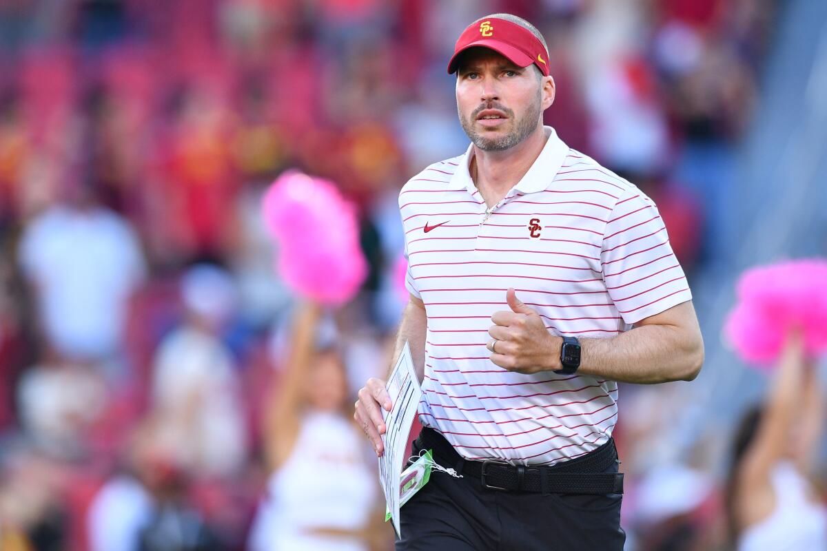 USC defensive coordinator Alex Grinch jogs on the field.