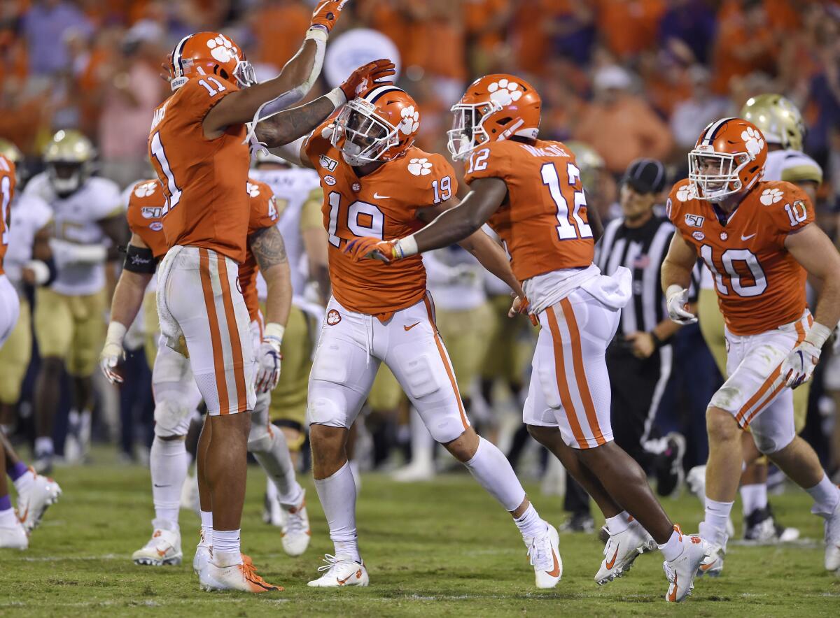 Clemson's Tanner Muse, center, Isaiah Simmons, left, and K'Von Wallace celebrate Muse's interception during the second half against Georgia Tech on Thursdayin Clemson, S.C. Clemson won 52-14.