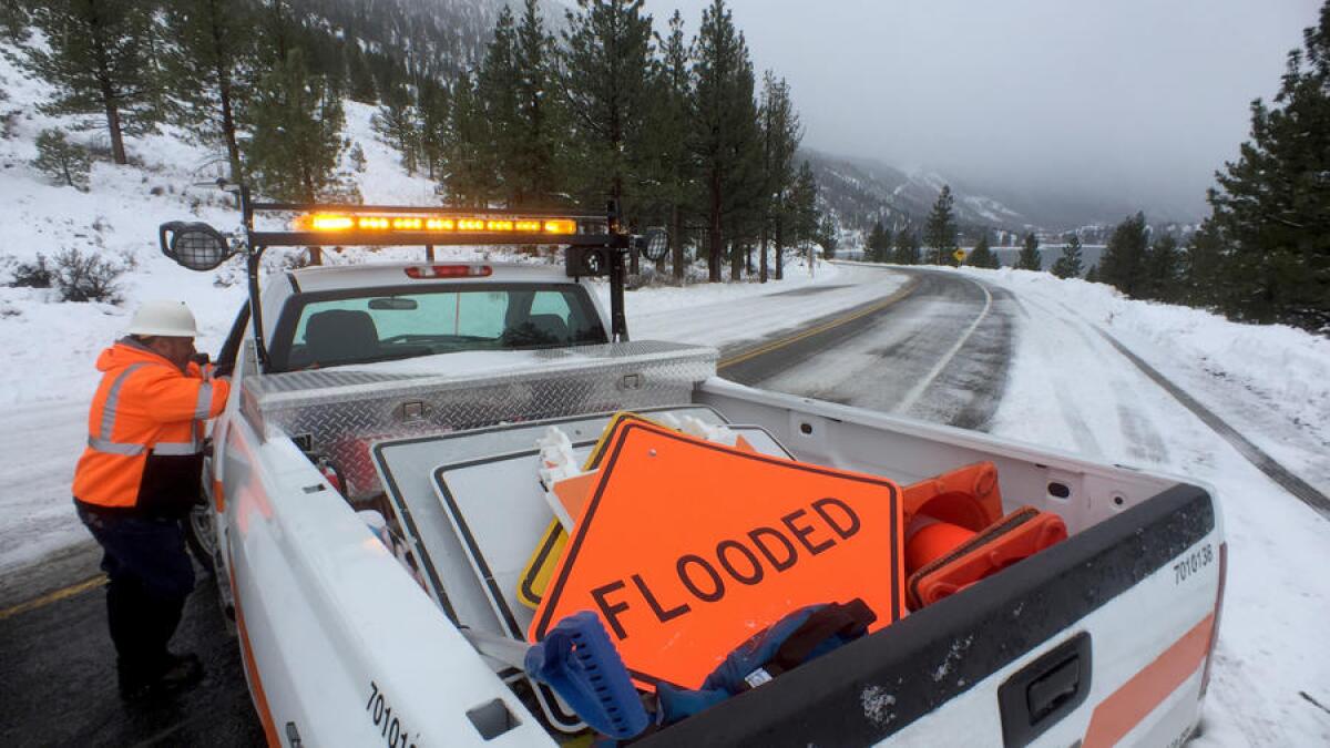 Caltrans crews prepare to post flood warning signs in anticipation of rain along Sierra Nevada highways.