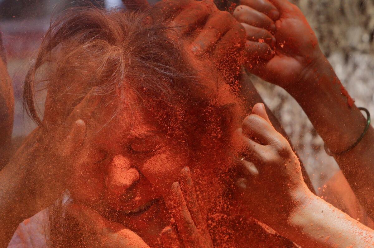 Revelers smear colored powder on a woman during celebrations marking Holi in Mumbai, India. (Rajanish Kakade / Associated Press)