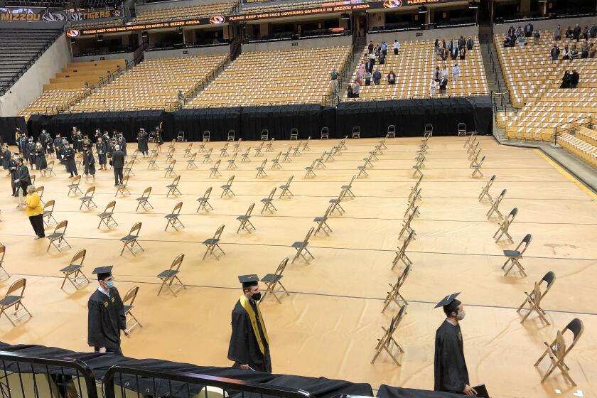 Inside the Hearnes Center at the University of Missouri where a make-up graduation ceremony for the class of 2020 was held. The center, which seats more than 13,000, swallowed the few hundred family members in socially distanced assigned seating. The grads, meanwhile, made their way to folding chairs set on the arena's floor at six-foot intervals.