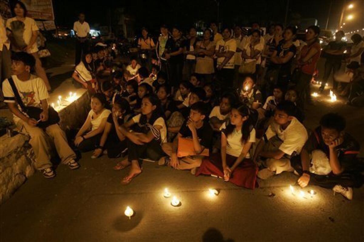 Residents listen during a candle lighting rally in Koronadal city, south Cotabato province, southern Philippines on Wednesday Nov. 25, 2009 to protest recent killings in Maguindanao. Officials recovered 11 more bodies Wednesday, six in a large pit buried with the wrecks of three vehicles and five in a third mass grave, bringing the death toll in Monday's attack on an election caravan to at least 57. (AP Photo/Aaron Favila)
